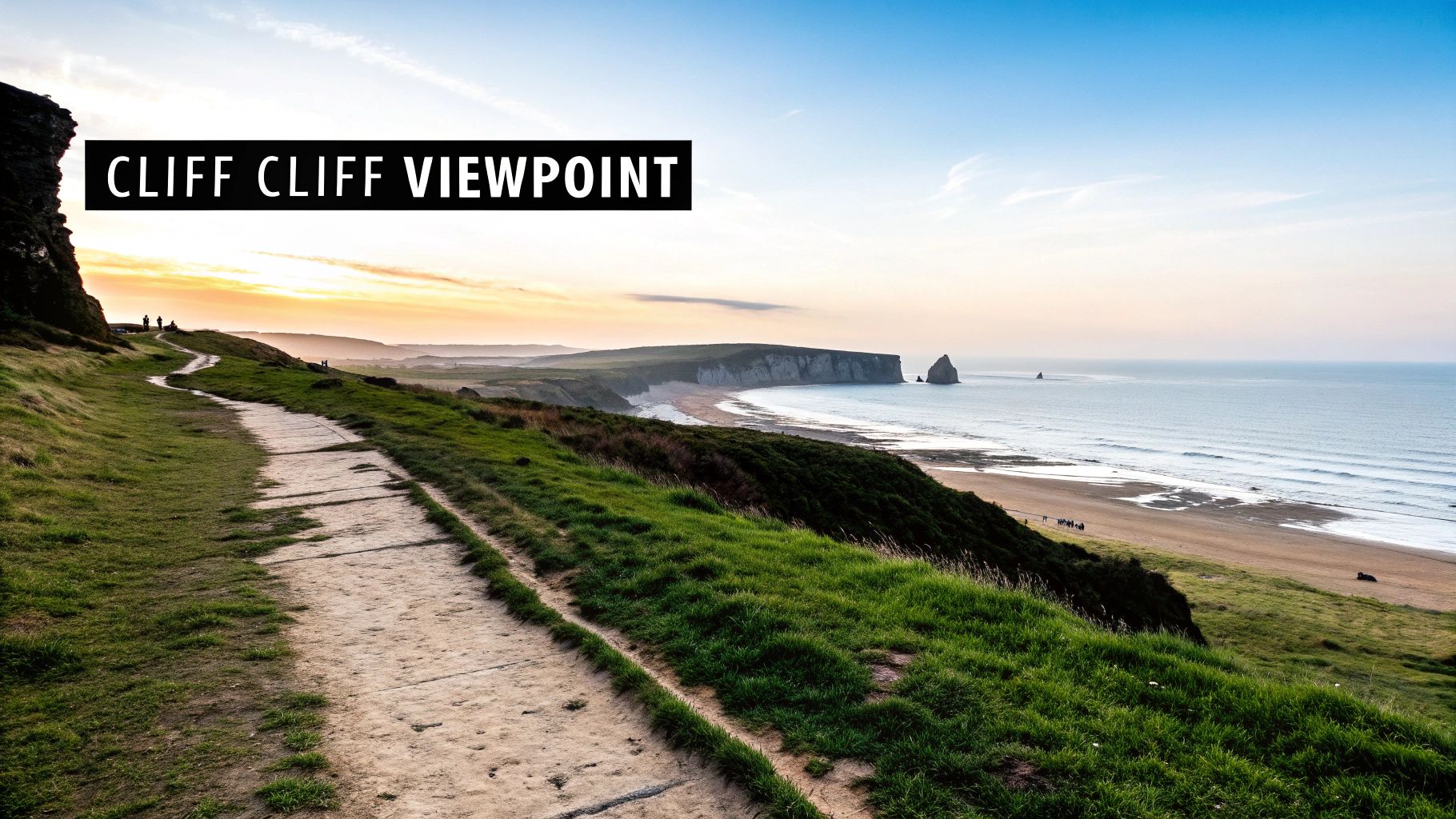 A scenic coastal path winds along grassy cliffs towards a sandy beach and ocean with sea stacks at sunset.