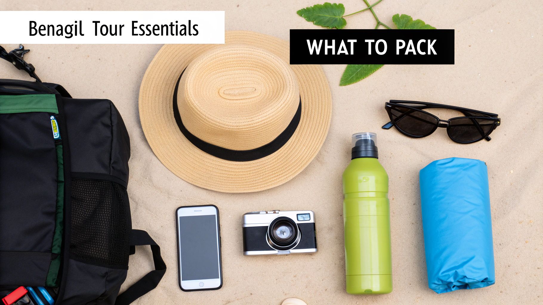 Flat lay of Benagil tour essentials on sand: backpack, hat, sunglasses, camera, phone, water bottle.