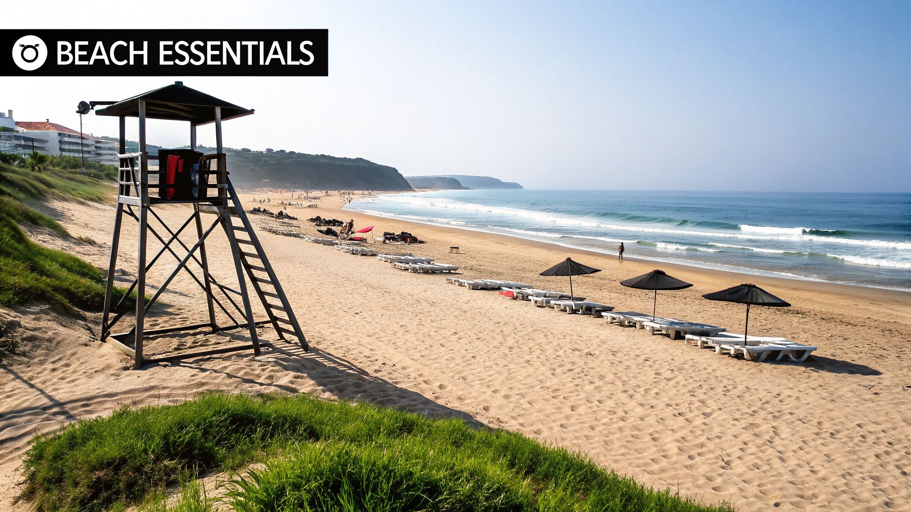 A sunny beach scene featuring a tall lifeguard tower, rows of white lounge chairs, black umbrellas, and ocean waves crashing on the sand.