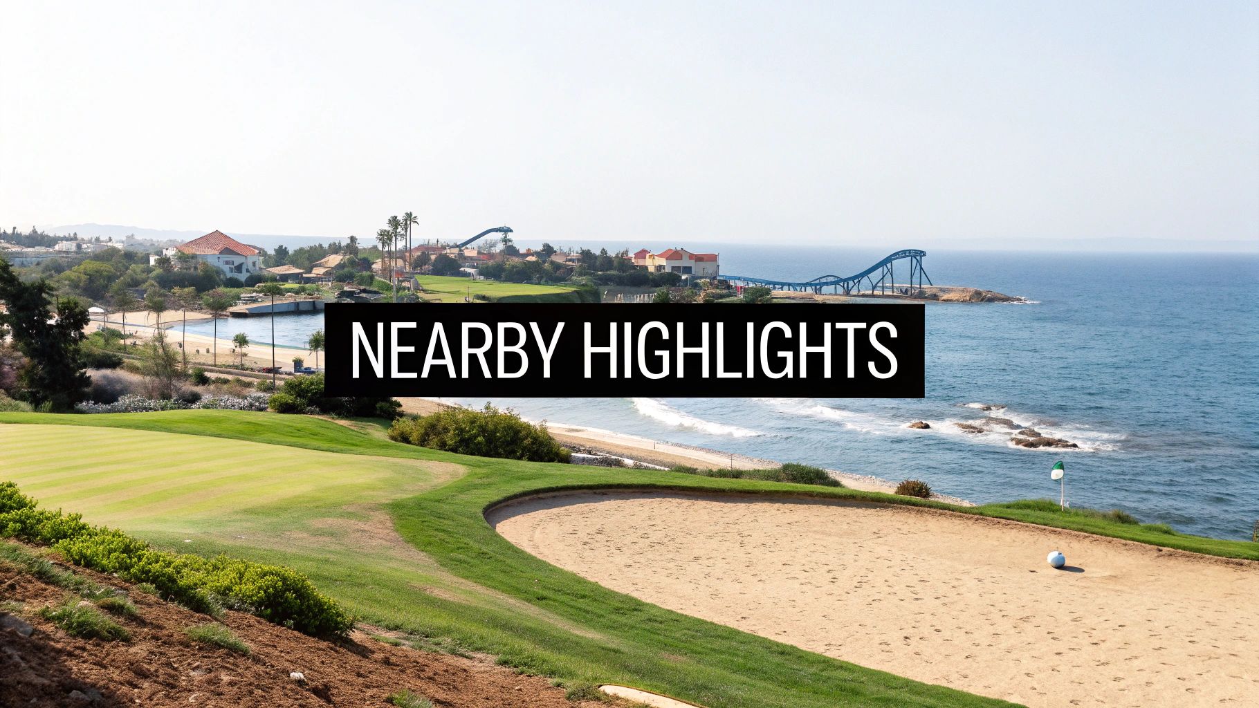 A scenic golf course with a sandy bunker overlooking the ocean, featuring a resort and water park.