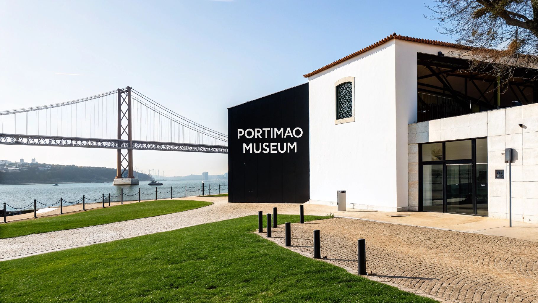 View of the Portimão Museum building with a large suspension bridge over water in the background.