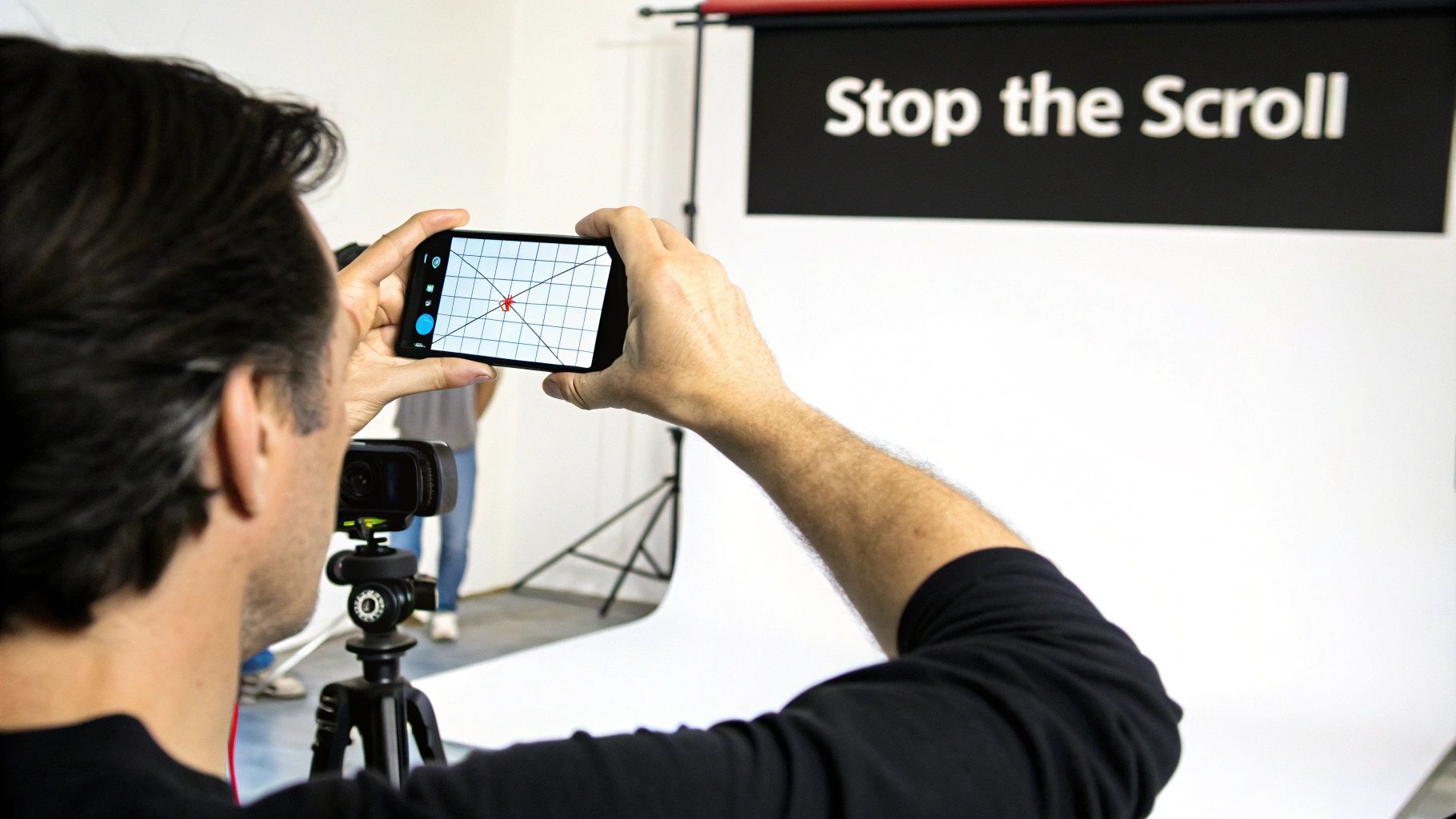 A person holds a smartphone horizontally, filming content in a studio with a 'Stop the Scroll' backdrop.