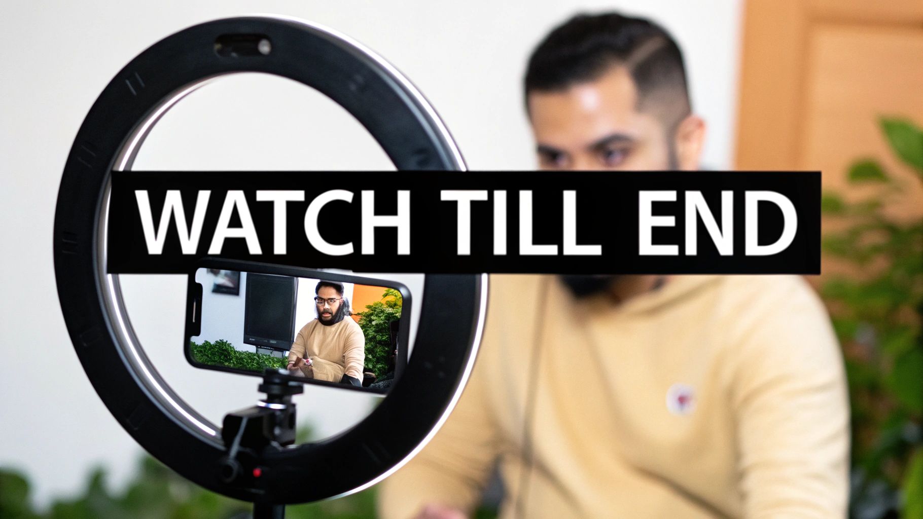 A content creator using a ring light and smartphone to record a video with a 'WATCH TILL END' overlay.