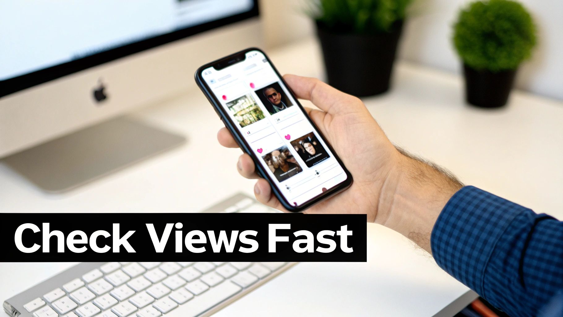 A hand holds a smartphone displaying a social media feed with profile pictures, on a desk with a computer.