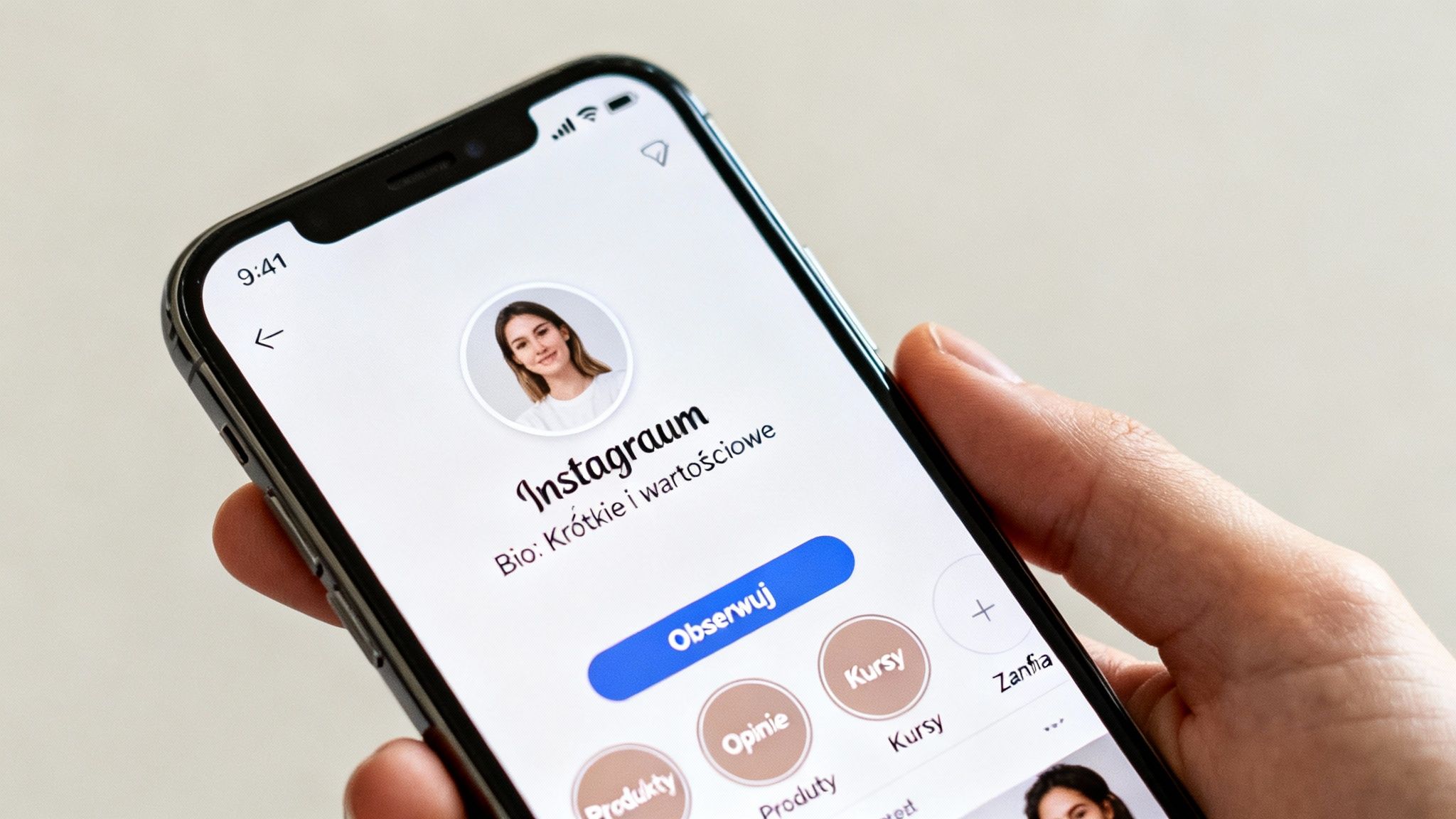 Osoba trzymająca iPhone'a z otwartym profilem Instagram. Widać zdjęcie profilowe, nazwę użytkownika, bio i przycisk 'Obserwuj'.