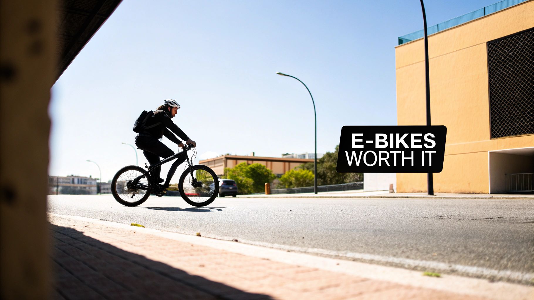 A man on a black e-bike cycles on a sunny street, with 'E-BIKES WORTH IT' text.