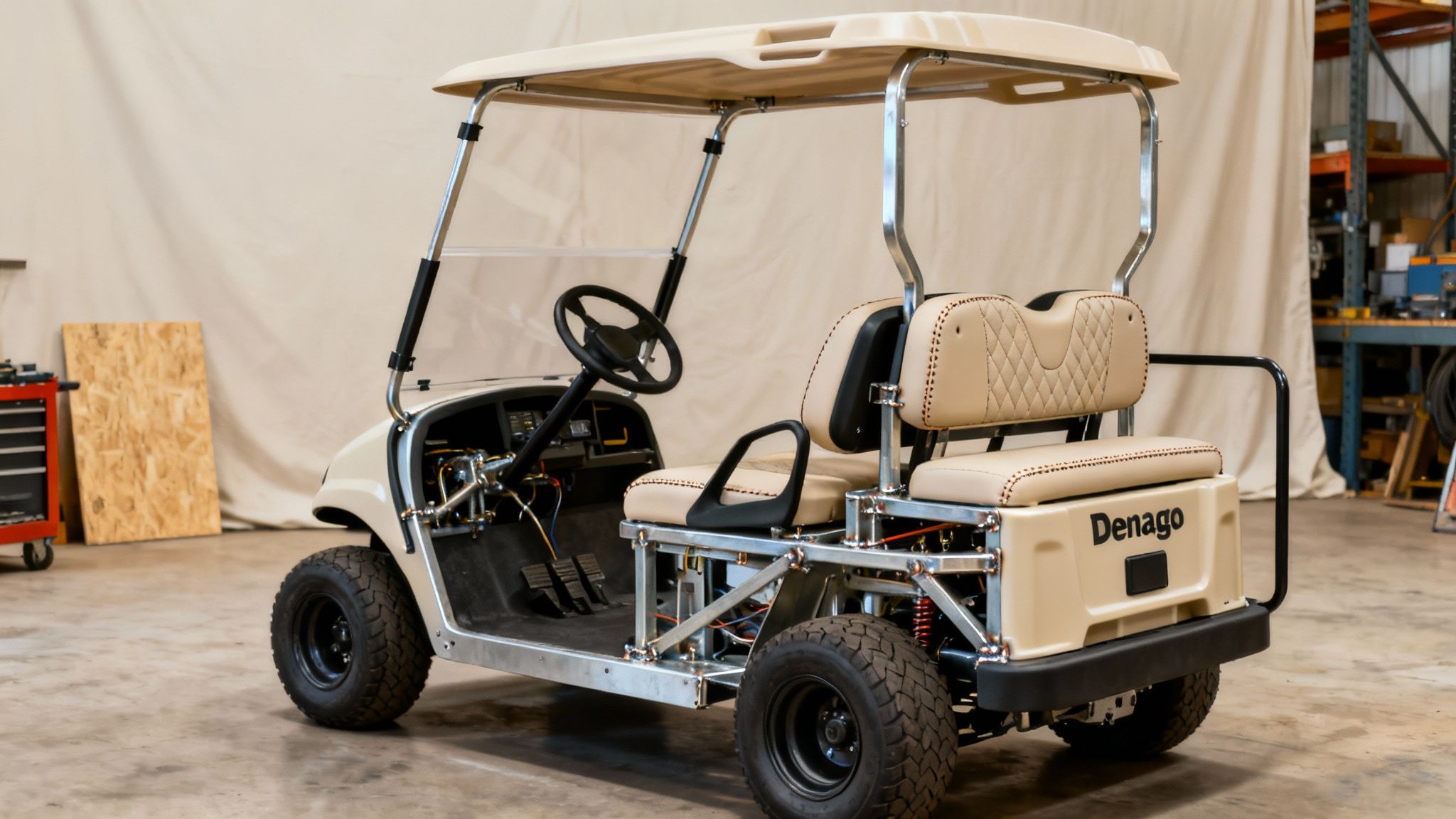 A customized Denago golf cart with beige body, tan quilted seats, and exposed metal frame.