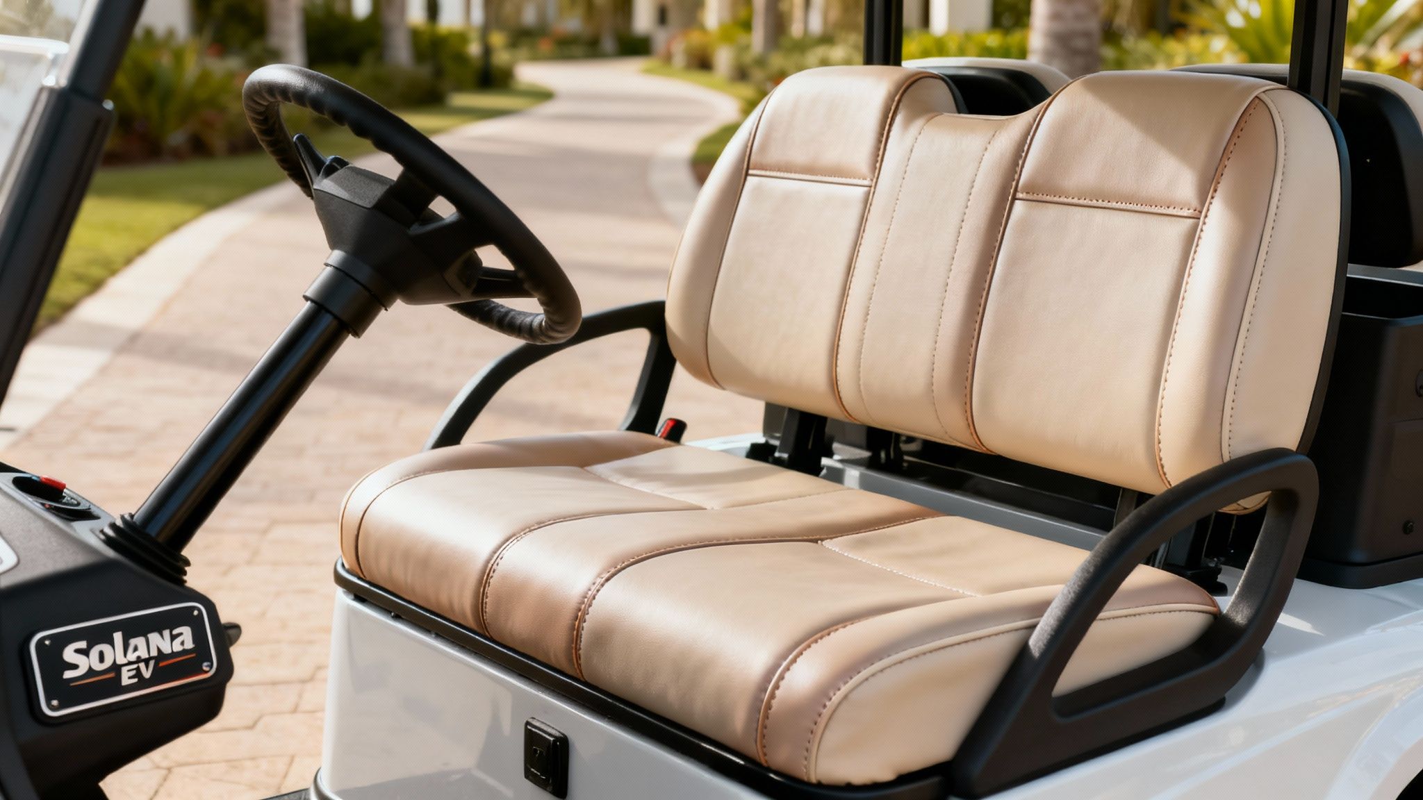 Close-up of a white Solana EV golf cart interior featuring custom beige and brown leather seats and steering wheel.