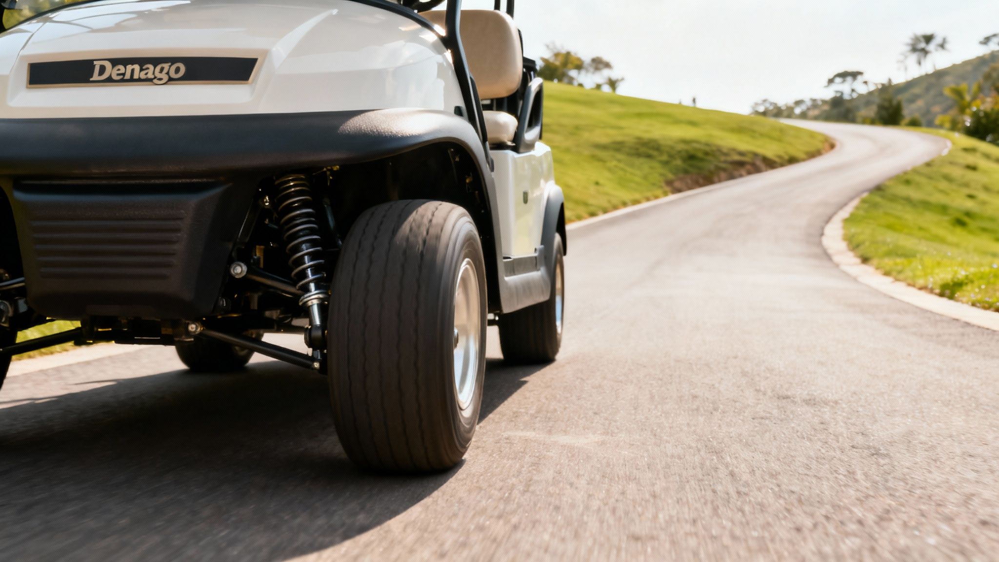 Denago golf cart moving on a winding road with green hills, highlighting its front suspension.