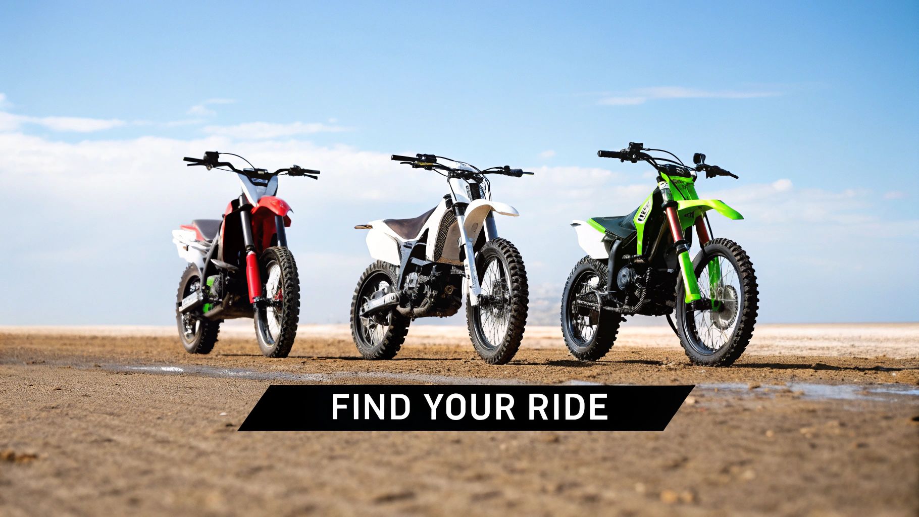 Three colorful electric dirt bikes, red, white, and green, parked on a vast, arid landscape.