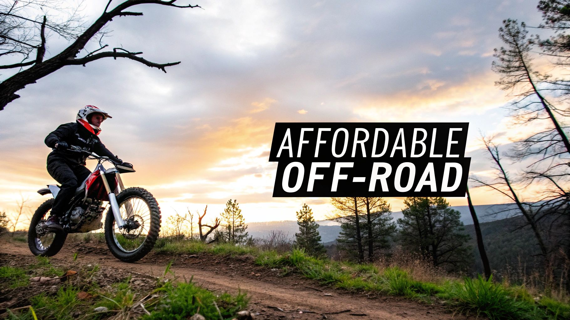 A person riding a red and white dirt bike on a dirt trail at sunset, with trees and a cloudy sky.