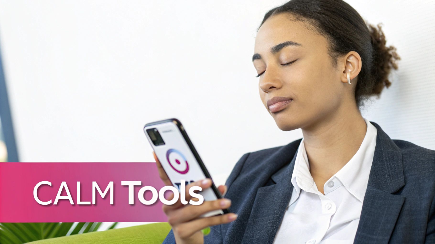 A woman with closed eyes meditates while holding a smartphone displaying a calm app.
