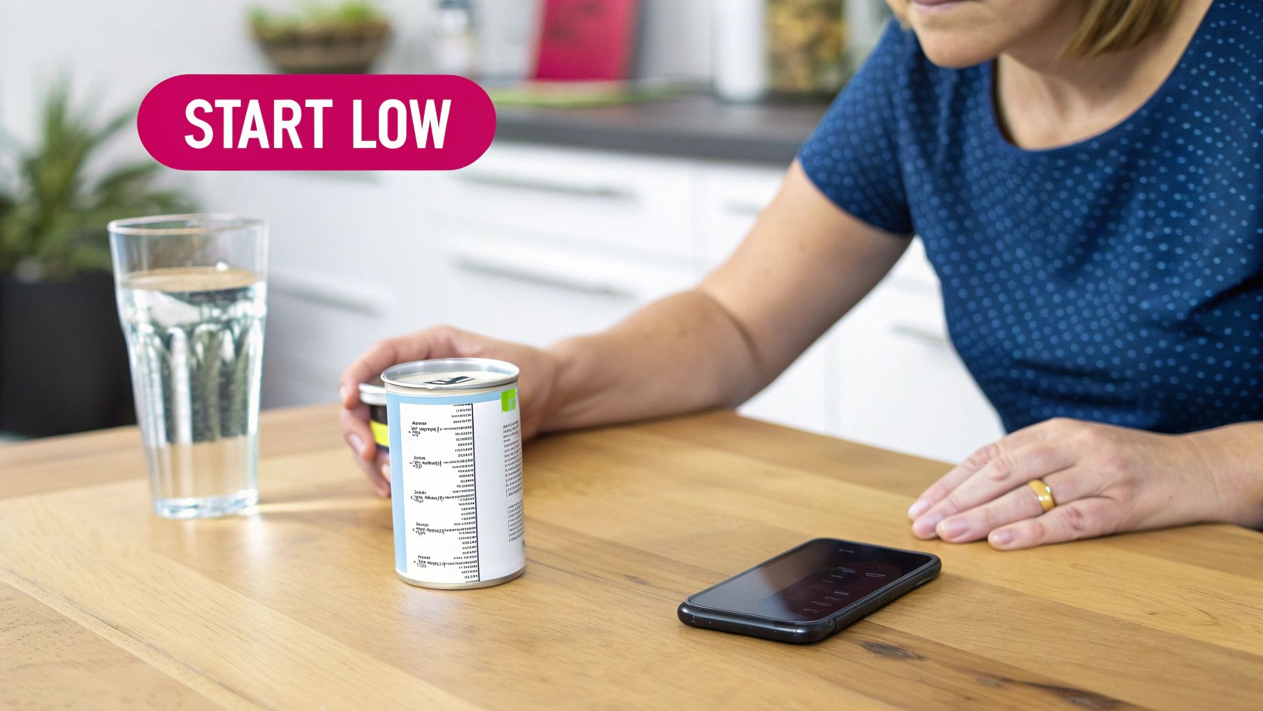 Person preparing to consume medication or supplement, with can, water, and phone on table, 'START LOW' visible.