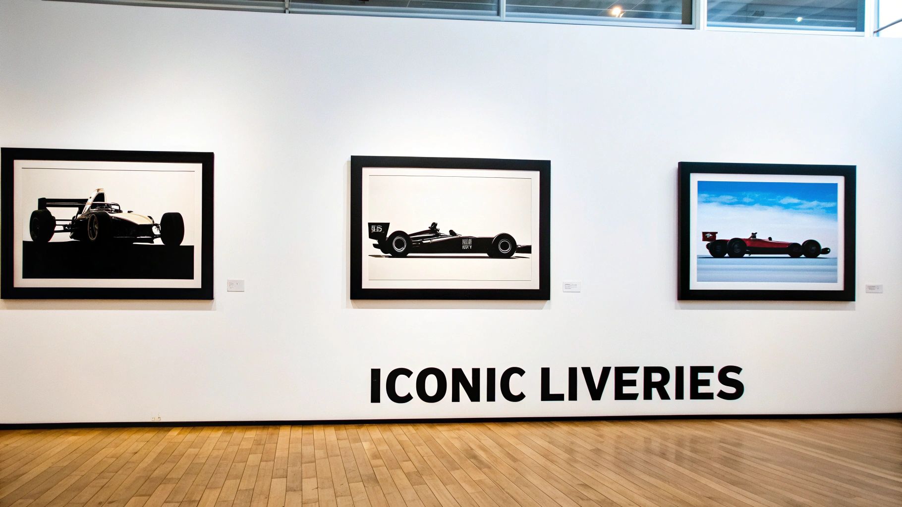 Gallery exhibition features three framed prints of classic Formula 1 racing cars, labeled 'ICONIC LIVERIES'.