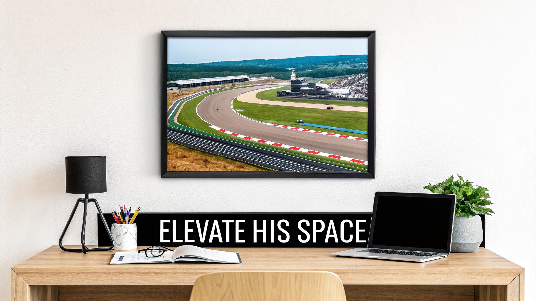 A modern home office setup with an F1 race track artwork above a wooden desk.