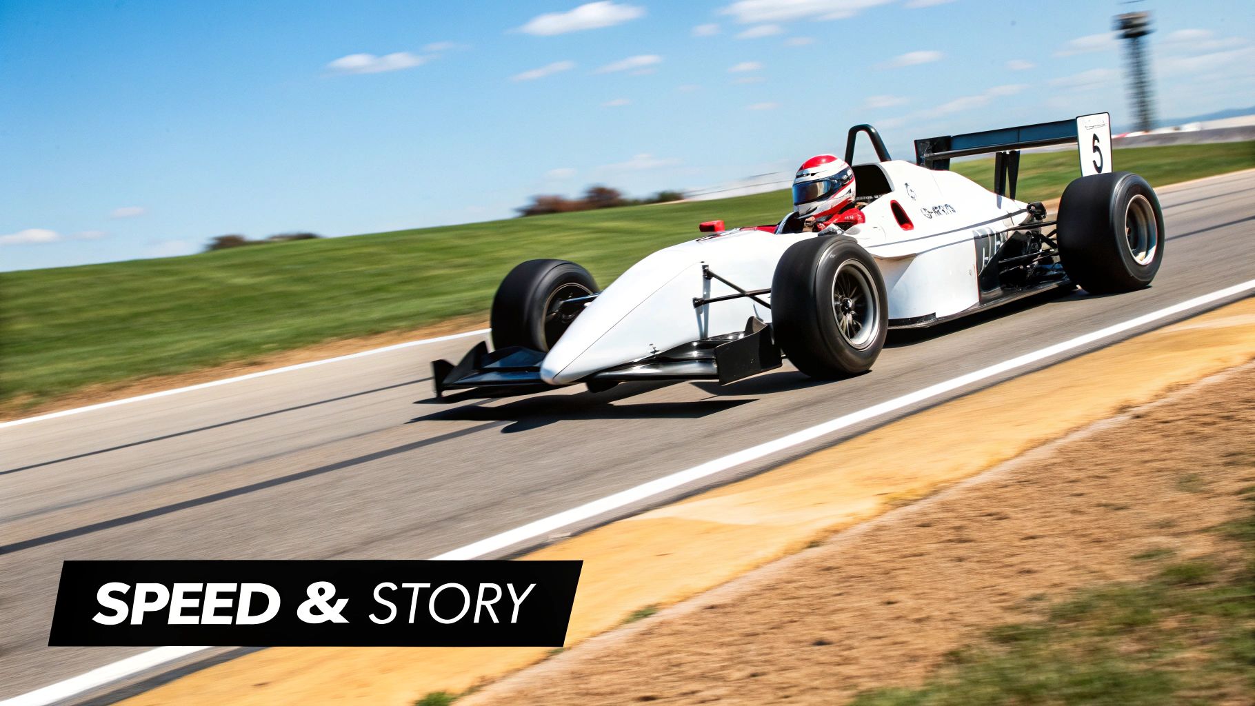 A white formula race car with a driver on a track, speeding past green hills under a blue sky.