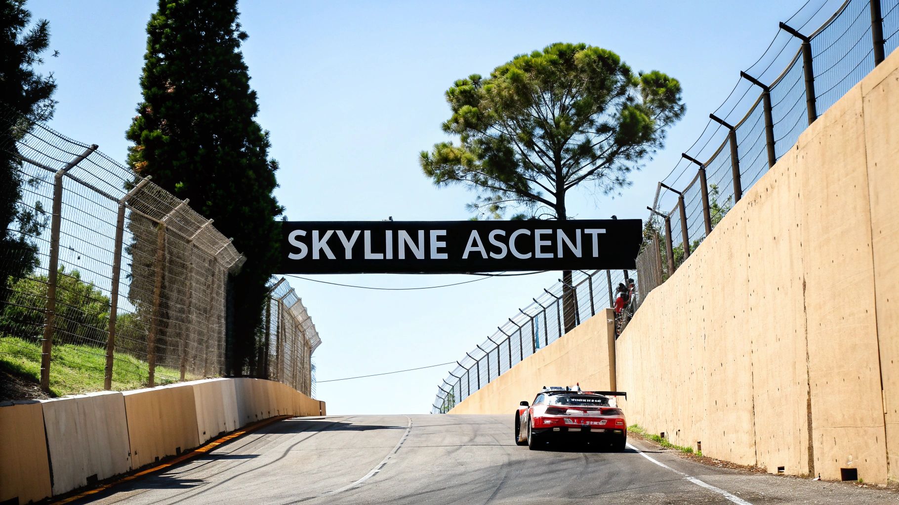 A red sports car ascends a race track under a 'SKYLINE ASCENT' sign on a sunny day.