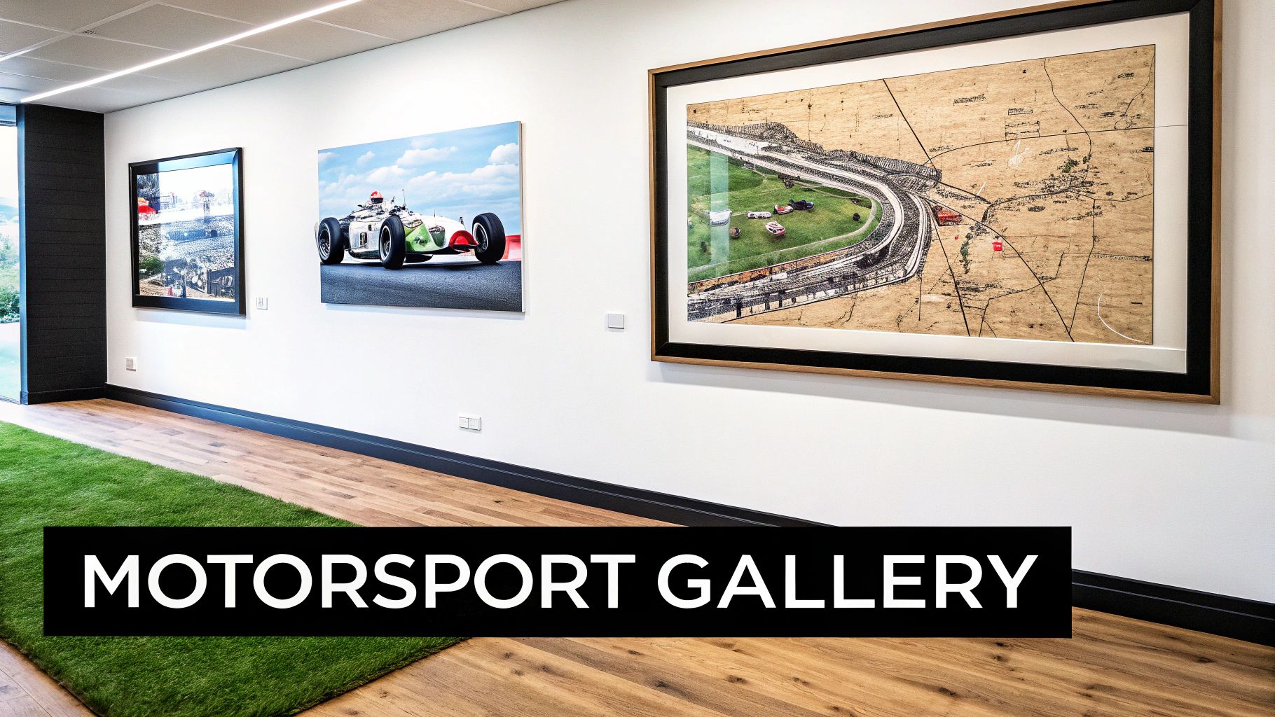 A bright motorsport gallery featuring race car artworks, a map, wooden floor, and a green rug.