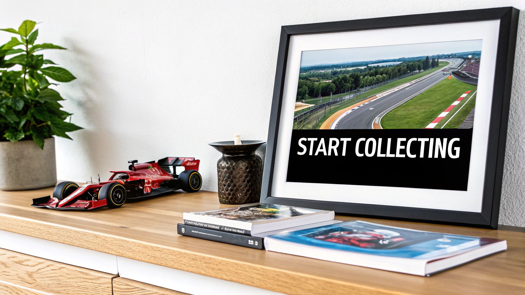 A detailed red Formula 1 model car on a wooden shelf with books and a framed race track image.