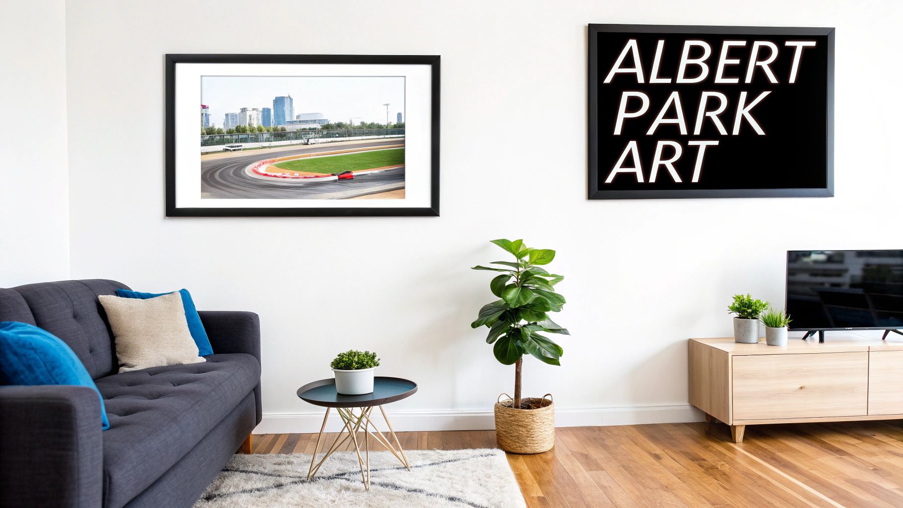 Modern living room featuring framed racing circuit art, a logo poster, sofa, and plants.