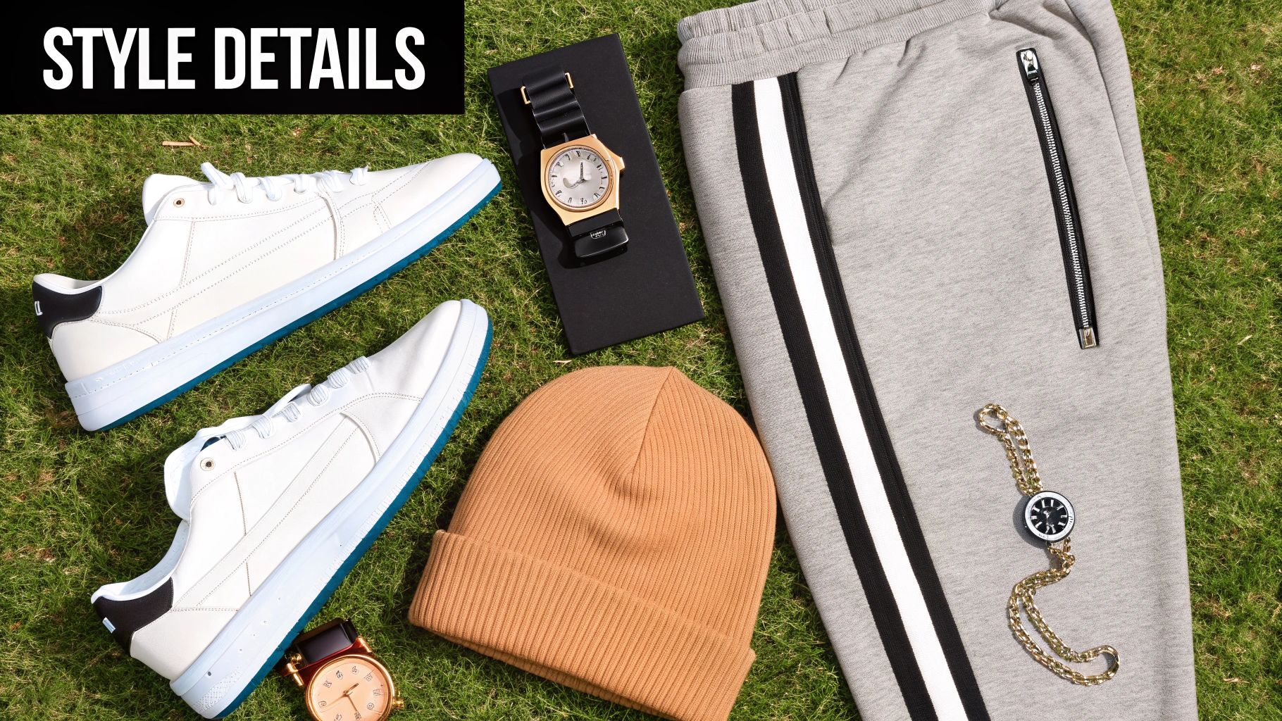 Flat lay of men's style details including white sneakers, watches, beanie, and grey track pants on grass.