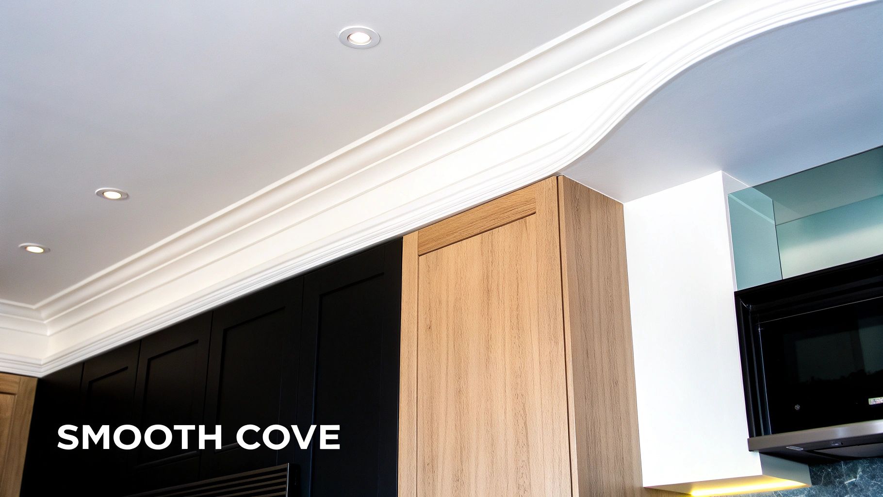 Modern kitchen featuring smooth cove crown molding on ceiling, recessed lights, and stylish cabinets.