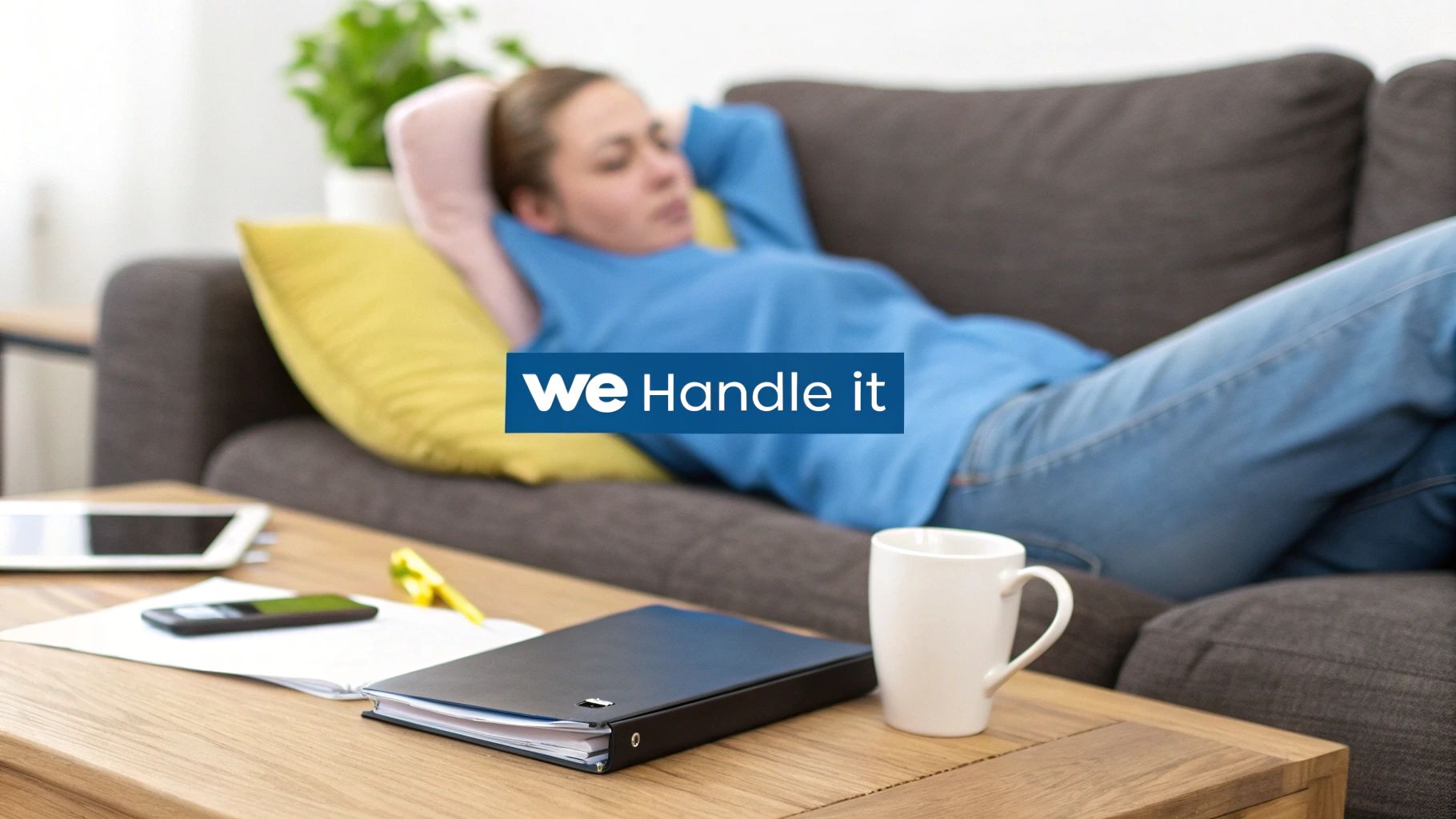 A person relaxing on a couch while work items like a tablet and notebook are on a coffee table, suggesting peace of mind.
