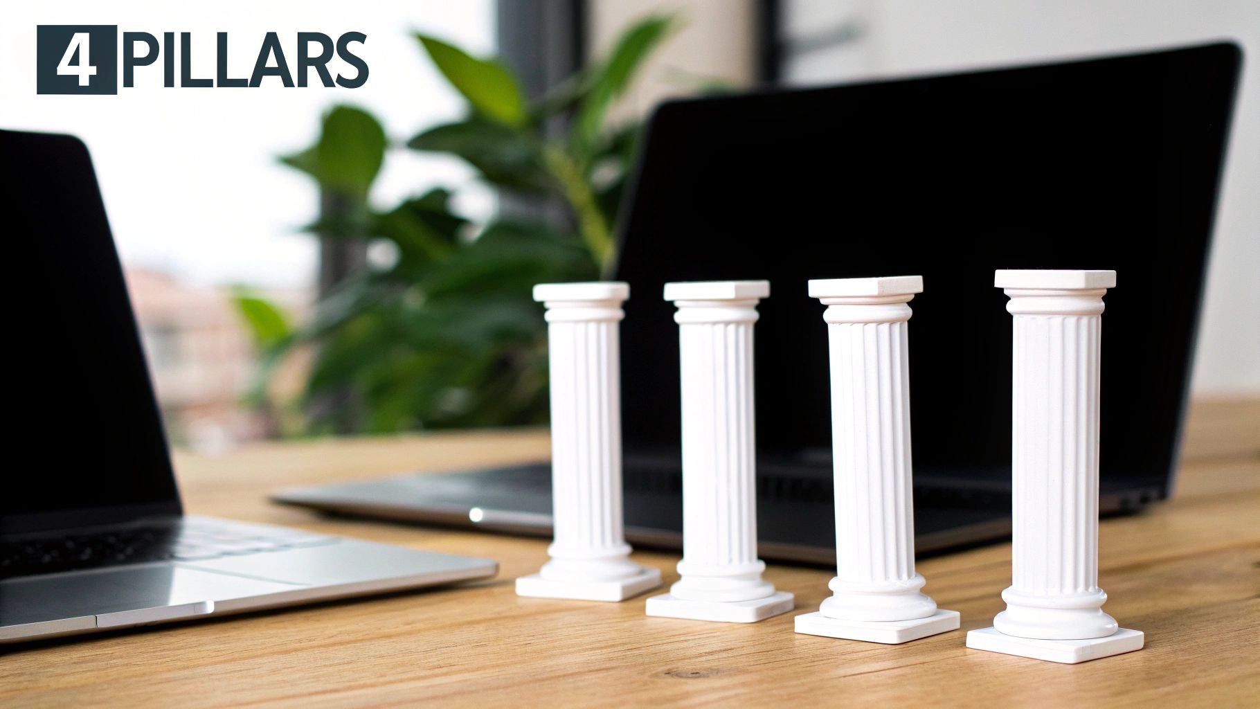 Quatre piliers blancs miniatures sur un bureau en bois, avec des ordinateurs portables et le logo 4 PILLARS.