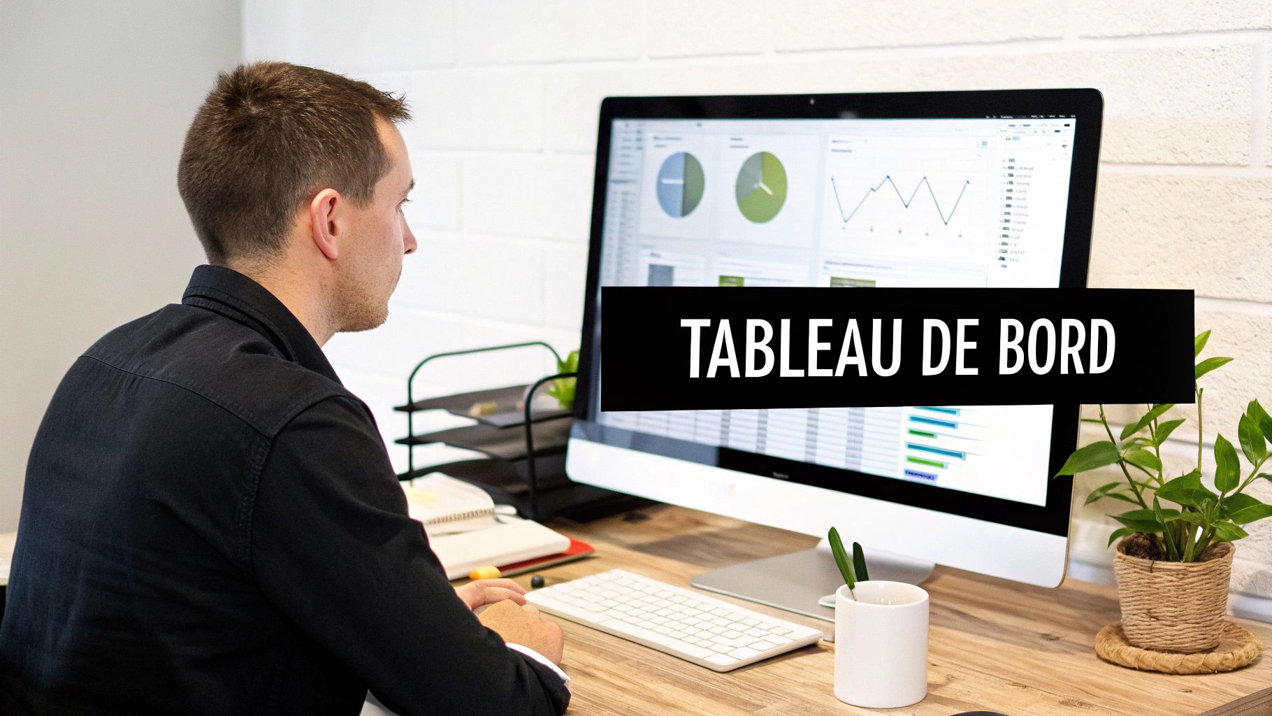 Un homme regarde un écran d'ordinateur affichant des graphiques et données d'un tableau de bord.