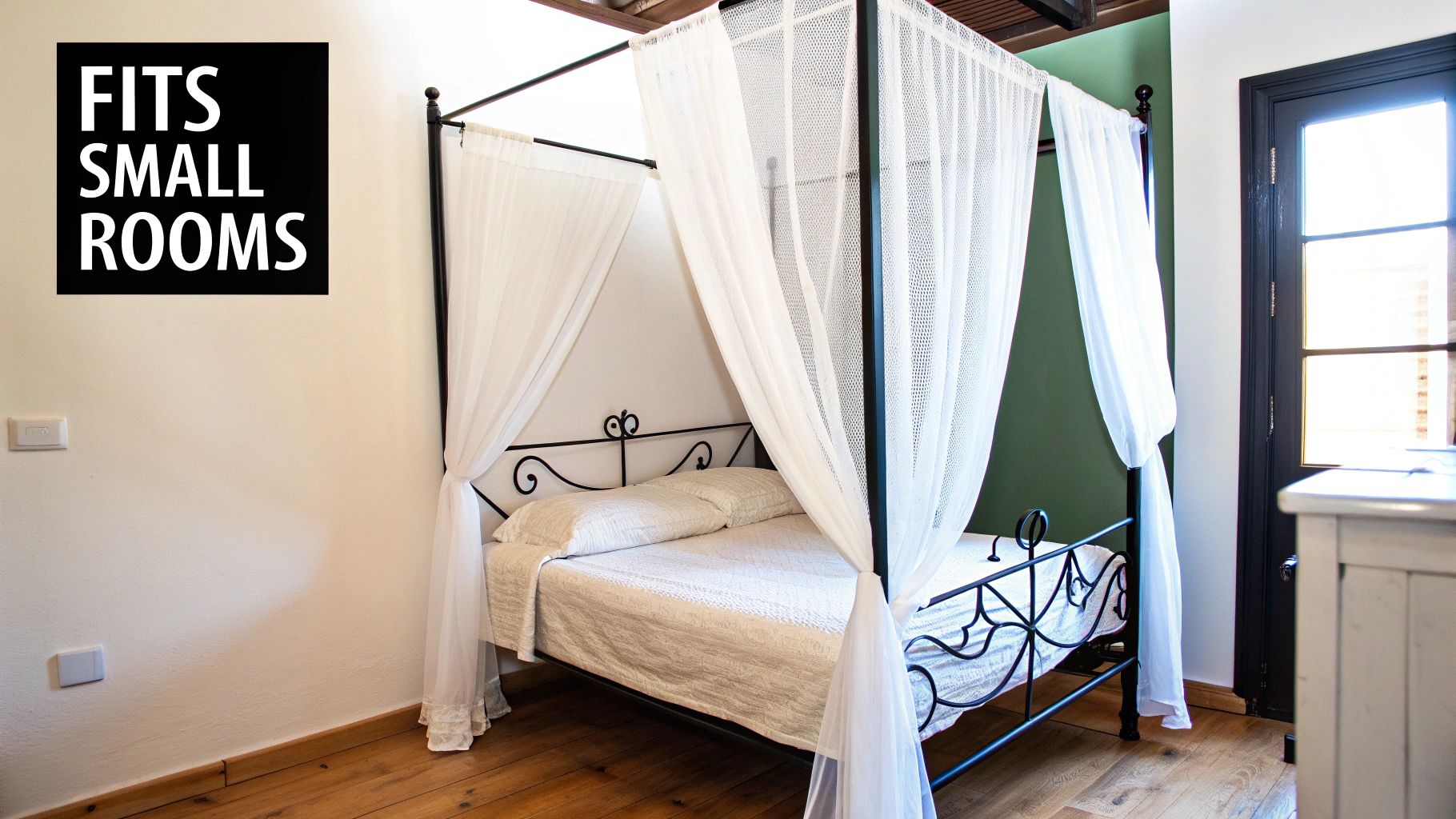 A stylish black canopy bed with white drapes in a small room with wooden floors.
