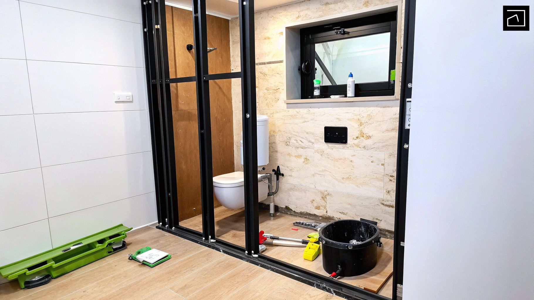 חדר רחצה מודרני עם אסלה תלויה לבנה על קיר אריחים אפור