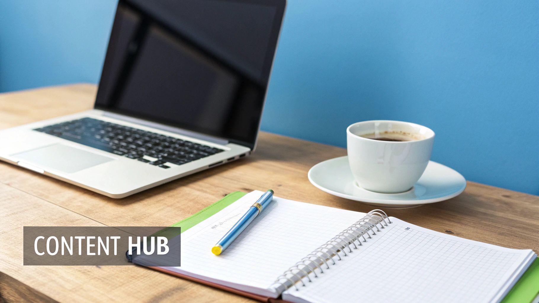 A workspace with a laptop, coffee, and notebook on a desk, featuring a 'CONTENT HUB' banner.
