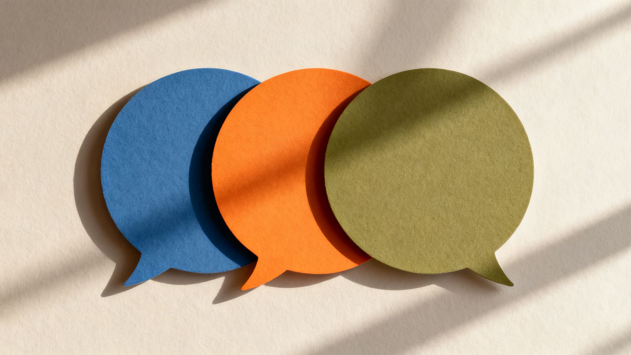 Three vibrant, overlapping speech bubbles in blue, orange, and green on a textured beige background with window shadows.