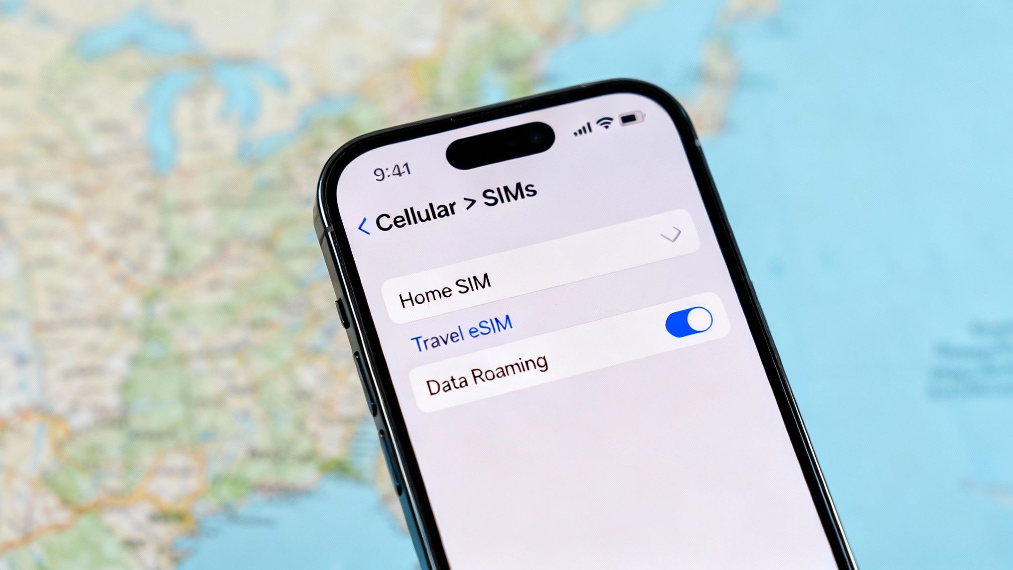 A person sitting on a bus, looking out the window while holding an iPhone, suggesting travel and connectivity.