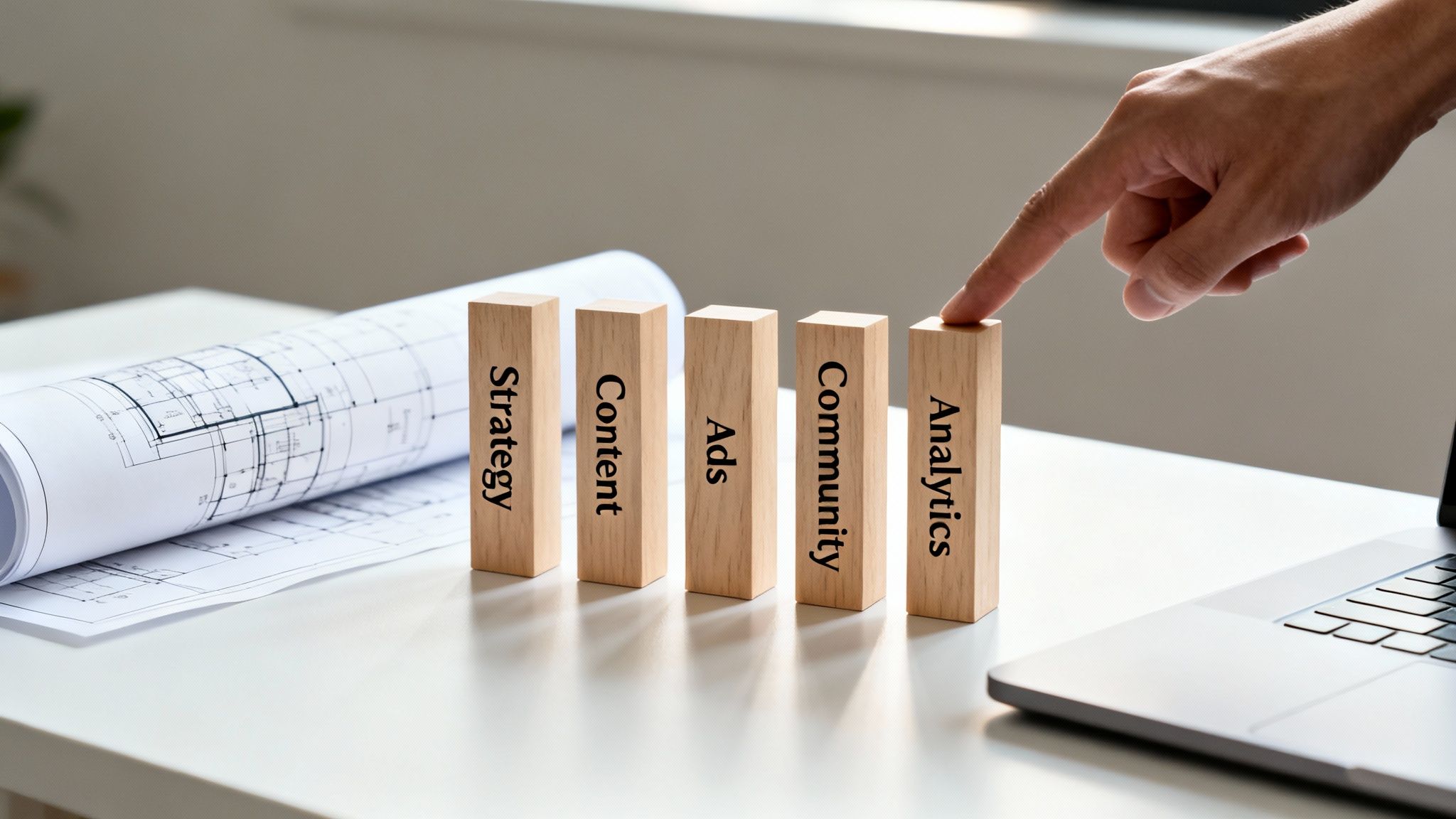 A hand touches a wooden block labeled "Analytics" amidst other marketing strategy blocks.