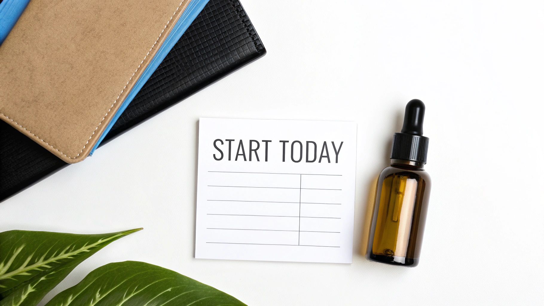 Flat lay of a 'Start Today' note, essential oil bottle, and notebooks on a white desk.