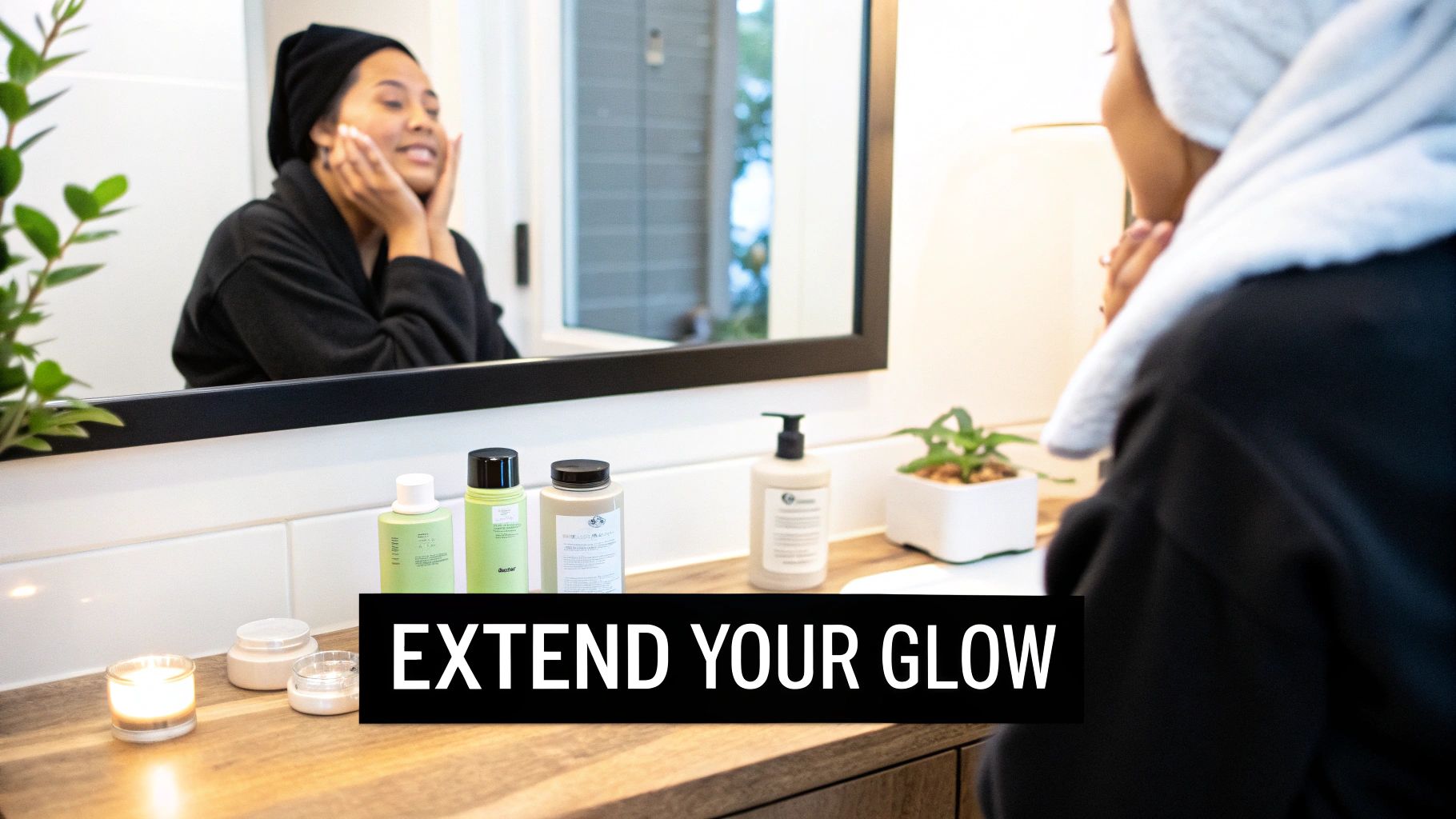 Smiling woman in a black robe applying face cream in a bathroom, with skincare products on the counter.