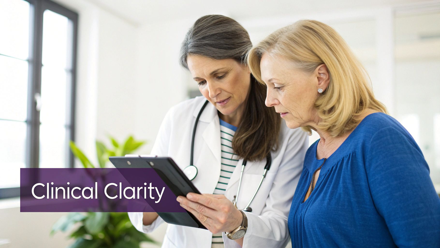A female doctor and patient closely examine a digital tablet, discussing medical information.