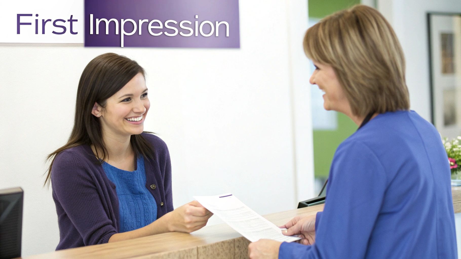 Two smiling women exchange a new patient intake form at a bright reception desk.