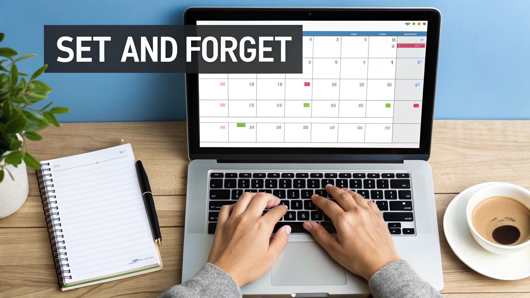 Overhead view of hands typing on a laptop with a calendar app, notebook, and coffee.