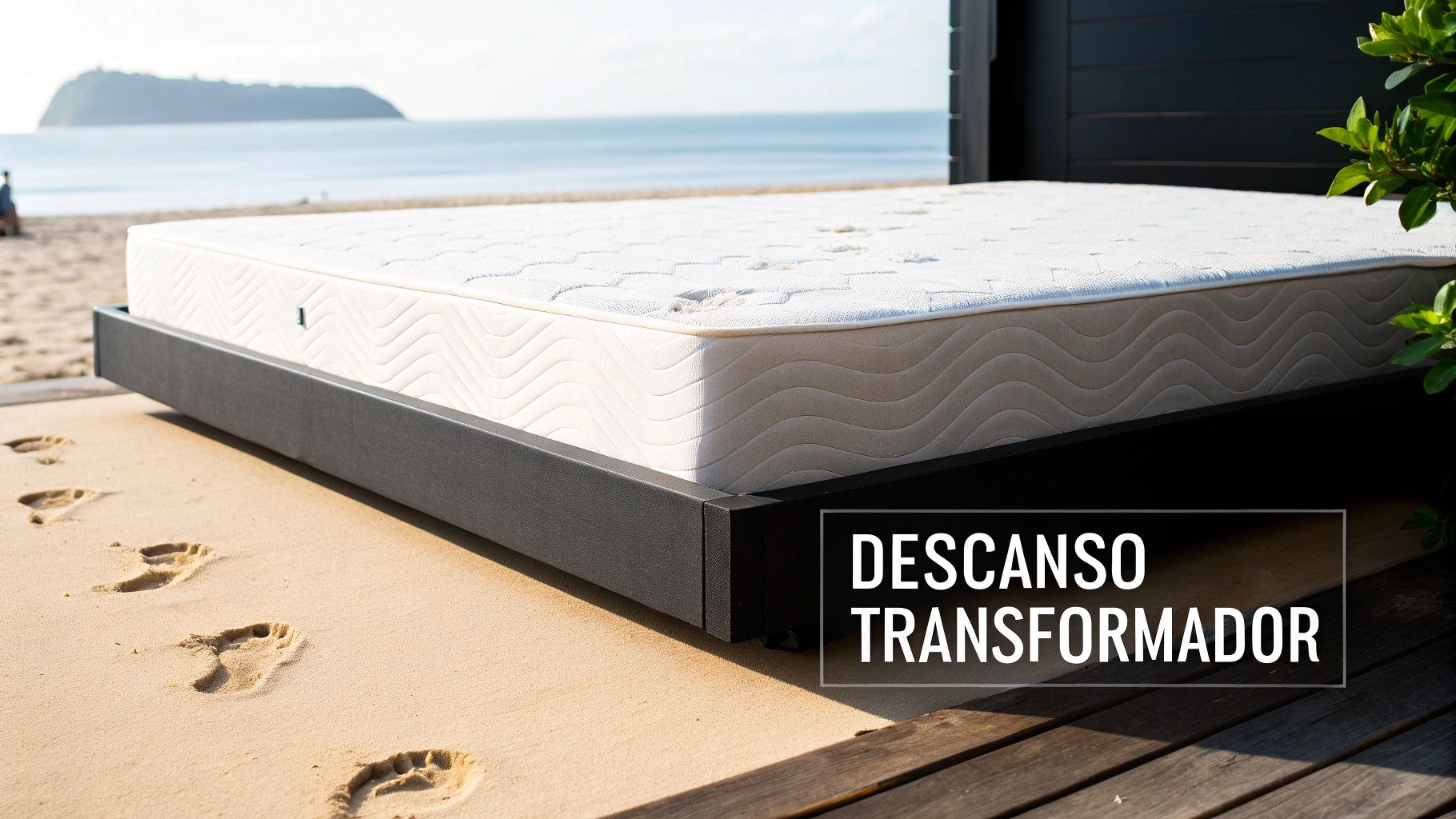 Un colchón blanco sobre una base de cama flotante en la playa, con huellas en la arena y el océano de fondo, evocando un descanso transformador.