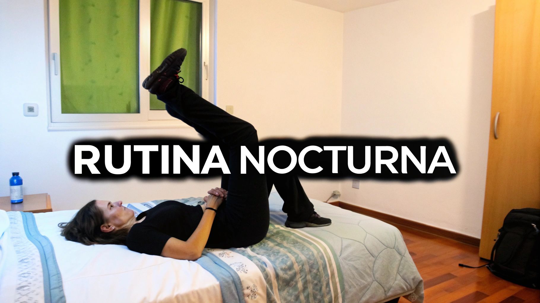 Mujer haciendo ejercicios de estiramiento en la cama con las piernas elevadas como parte de su rutina nocturna.