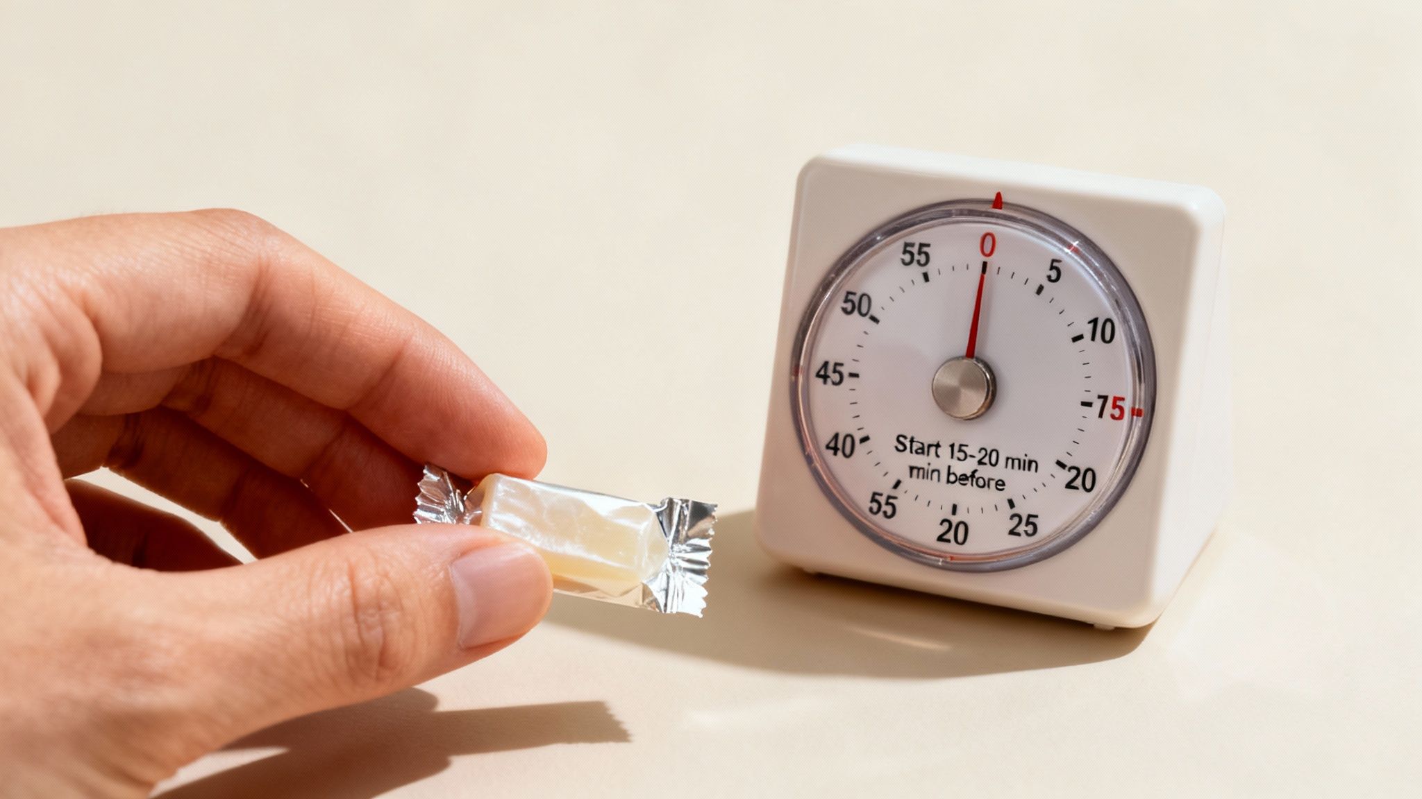 A hand holds a wrapped energy gum next to a kitchen timer set for 15-20 minutes.