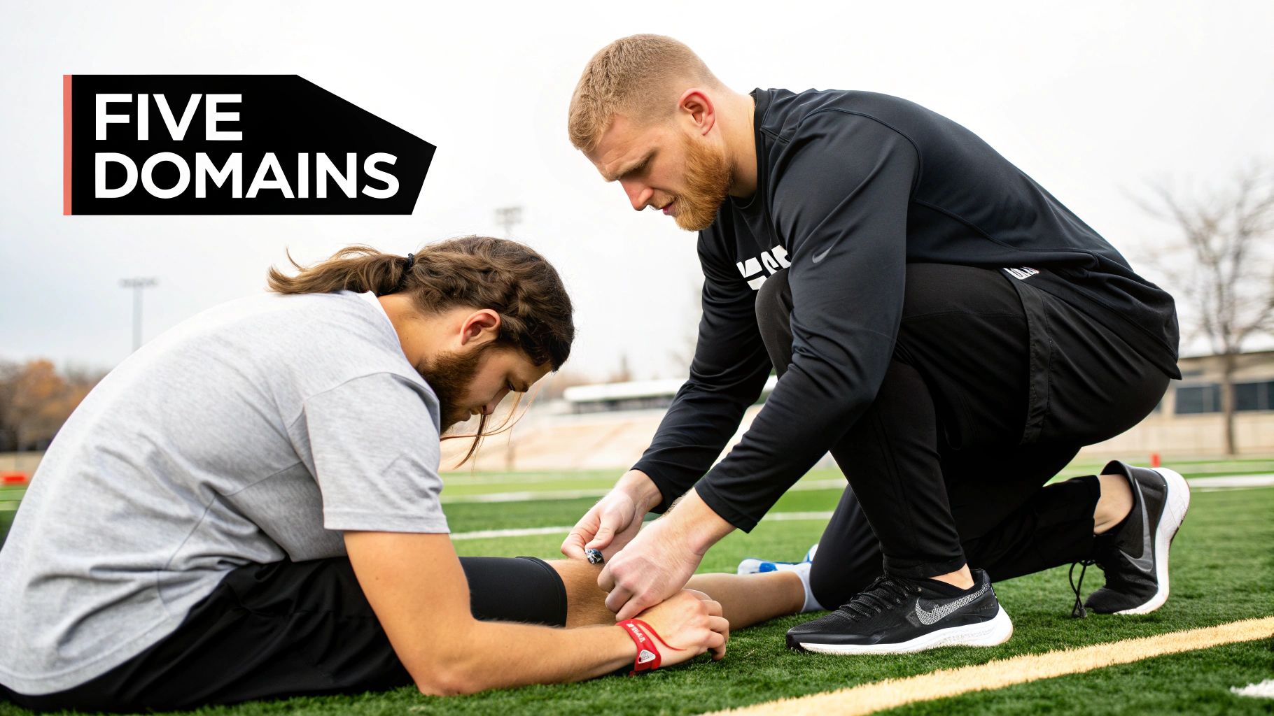 An athletic trainer reviews materials at a desk, preparing for an exam