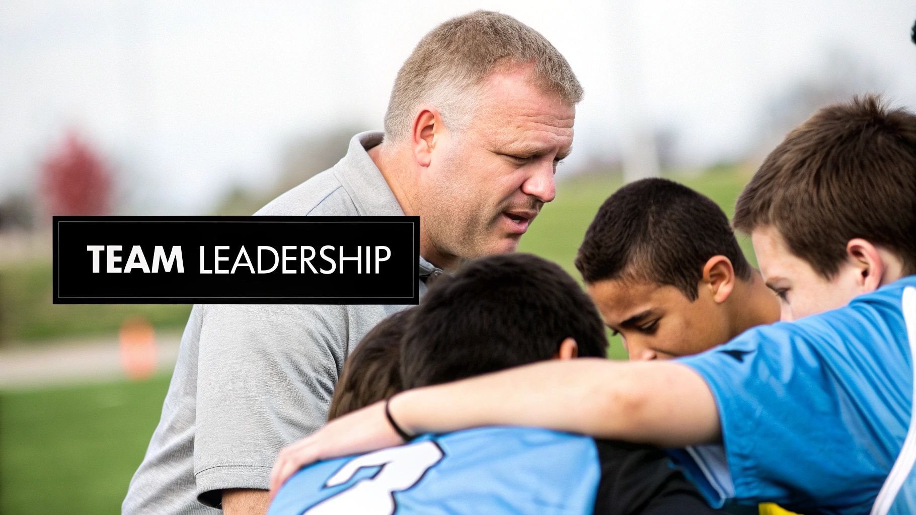 A male coach huddles with young athletes, offering guidance and exhibiting team leadership.