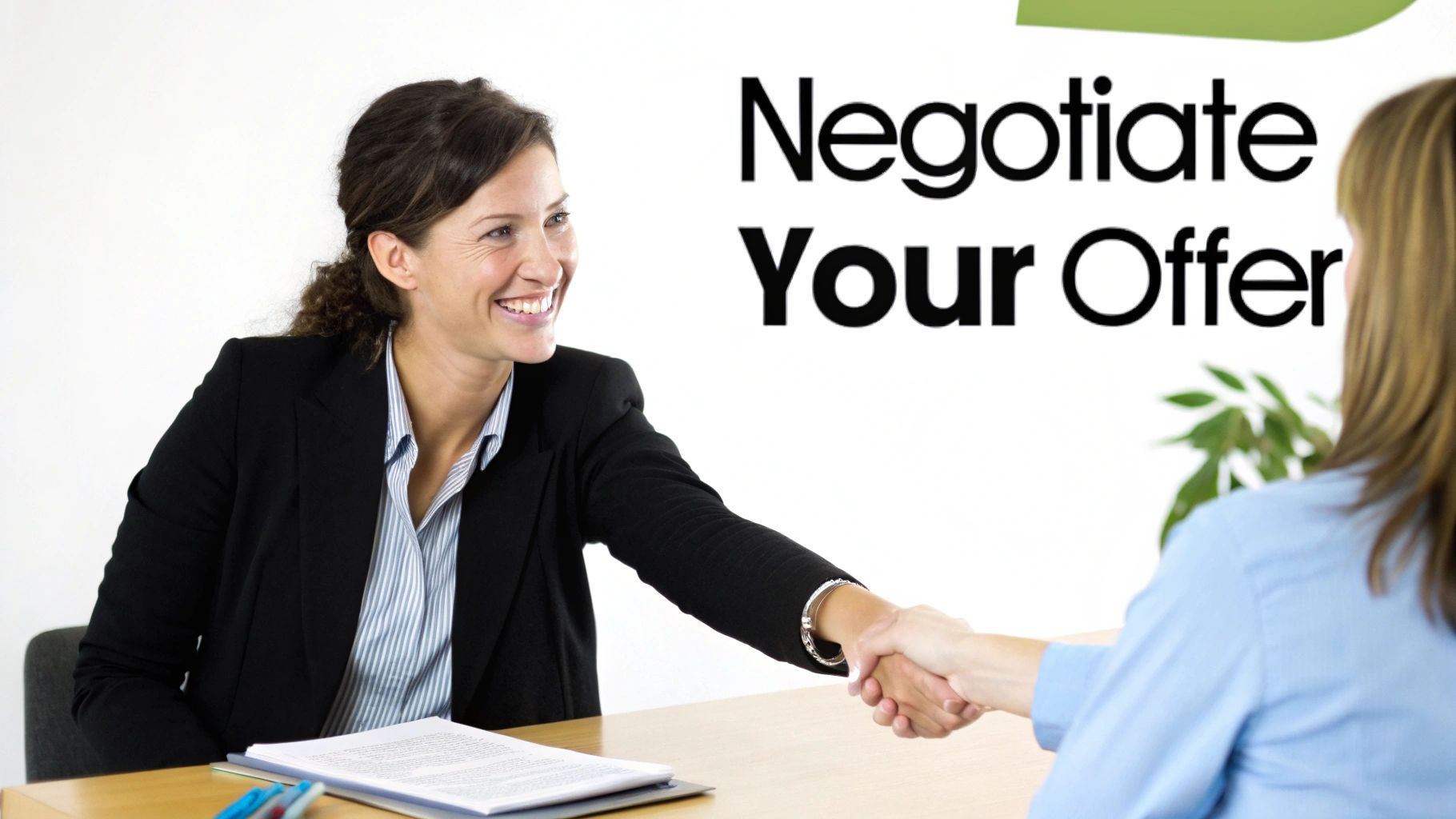 Two professional women shaking hands across a desk, one smiling, with text 'Negotiate Your Offer'.