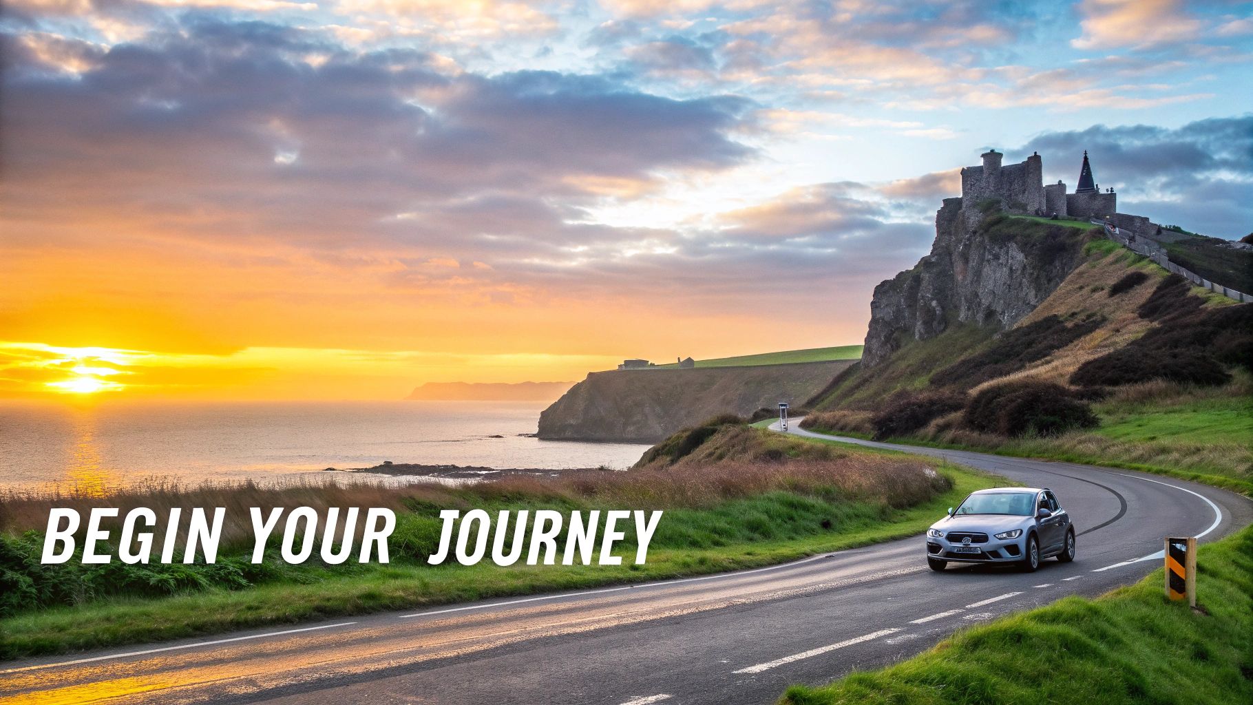 A silver car drives along a scenic coastal road with a historic castle at sunset, with text 'Begin Your Journey'.