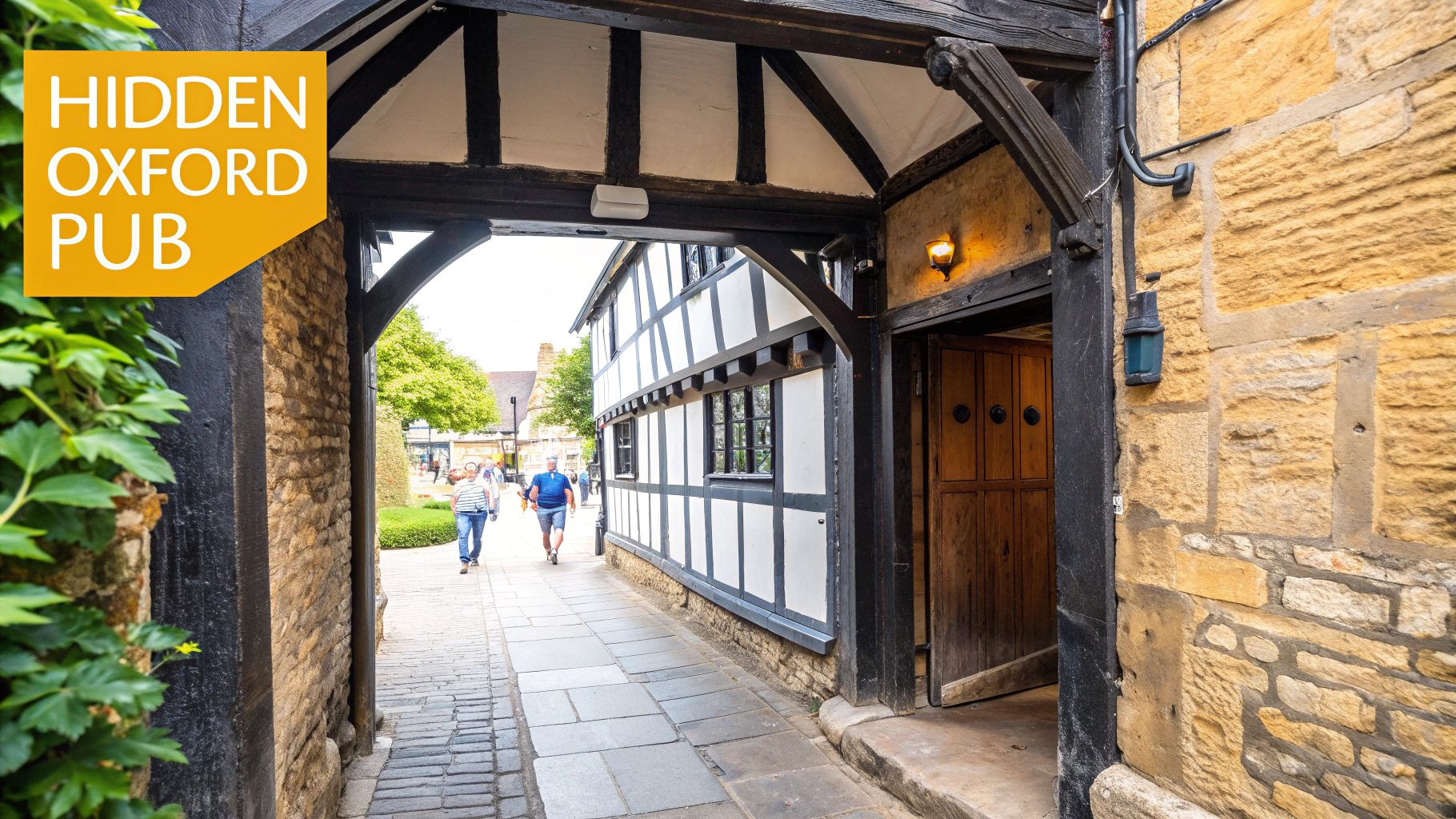 A narrow, stone-walled alley leads to a traditional timber-framed pub in historic Oxford, England.