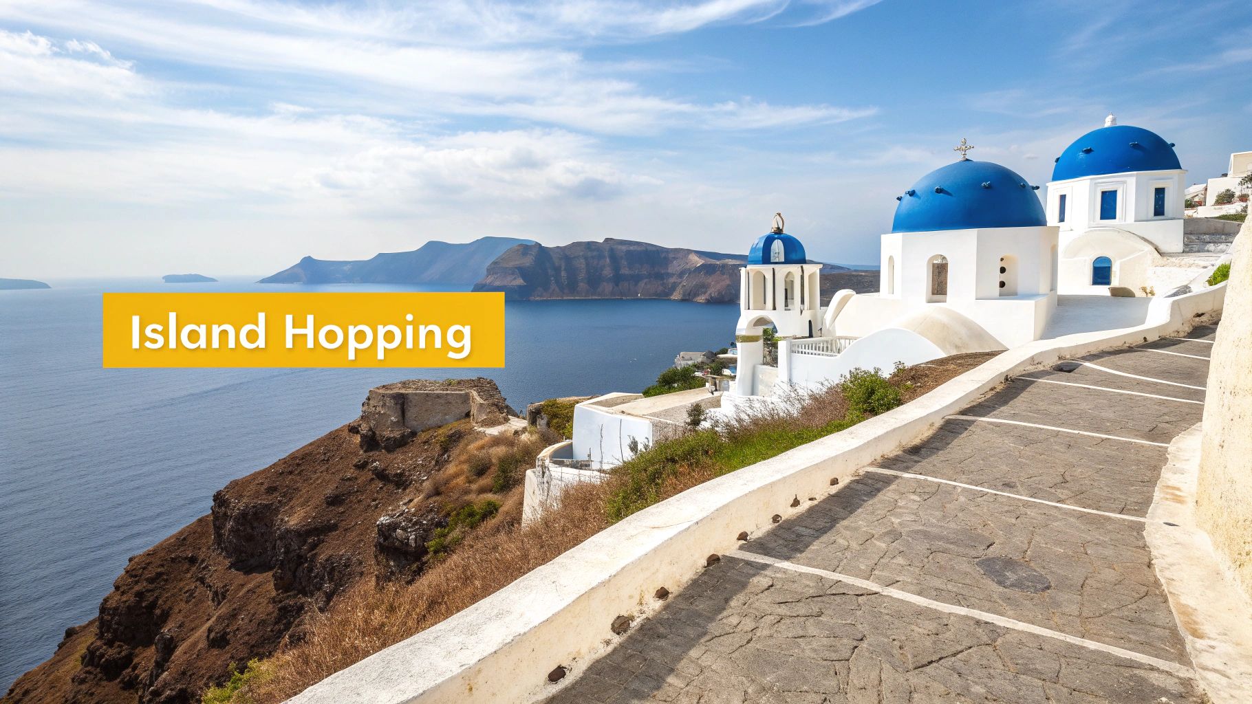 Beautiful view of white buildings with blue domes in Santorini, Greece, overlooking the Aegean Sea.