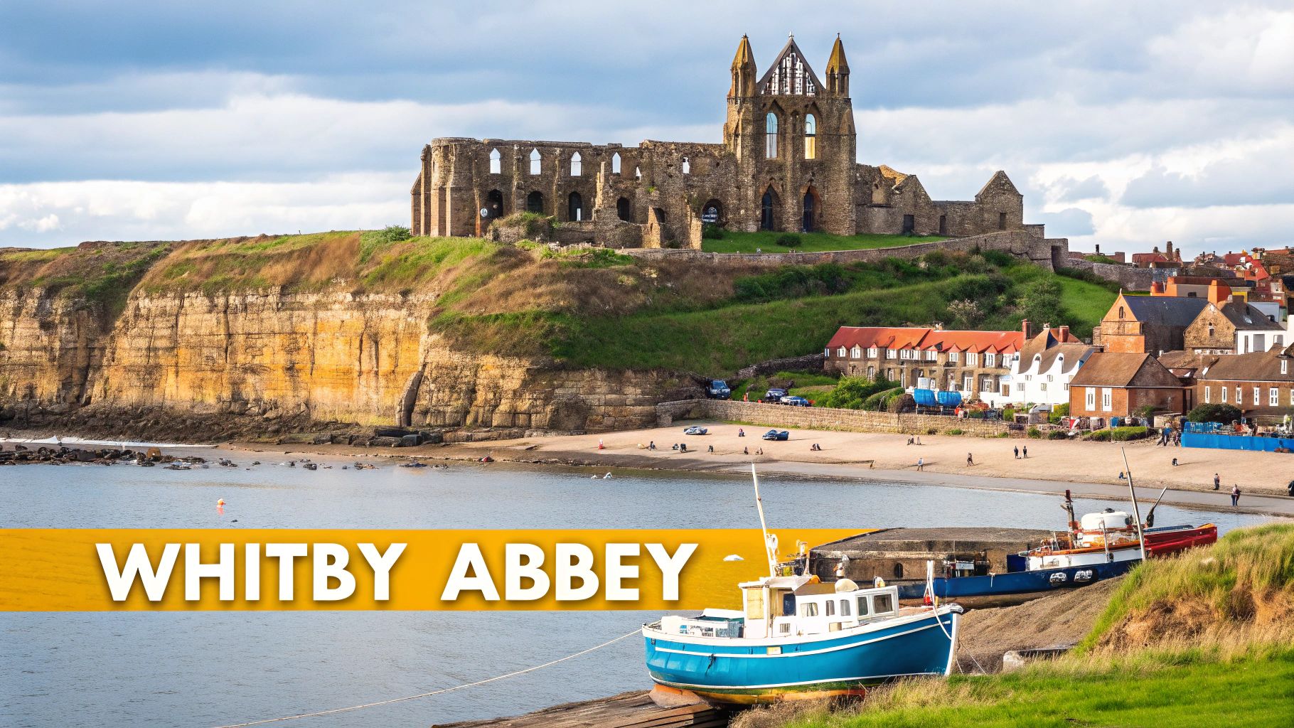 Whitby Abbey, a historical ruin, stands majestically on a cliff overlooking a charming bay with a sandy beach and colorful boats.